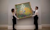 Sotheby's auction house staff pose for photographers with Austrian artist Gustav Klimt's 'Bauerngarten (Blumengarten)'