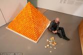 South African born artist Roelof Louw sits beside his sculpture 'Soul City (Pyramid of Oranges)', which has been bought by the Tate Modern for £30,000