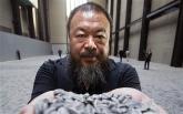 Ai Weiwei with a handful ceramic seeds during a photocall for the launch of 'Sunflower Seeds' at the Tate Modern